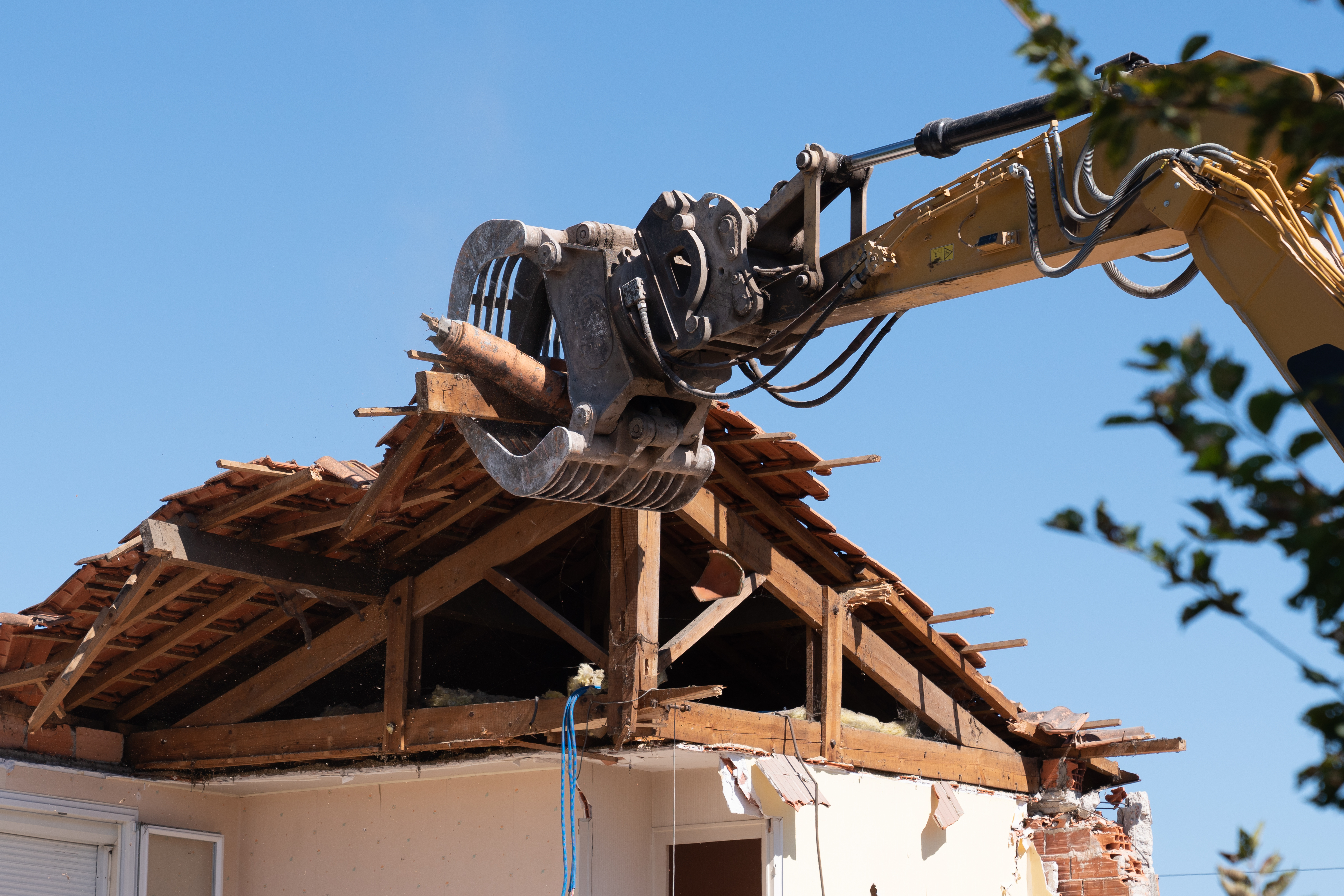 industrial excavator working demolition of house old residential